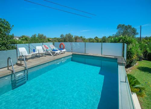 a swimming pool with two chairs in a yard at Owl Booking Villa Rafale - 5 Min Drive to The Beach in El Port