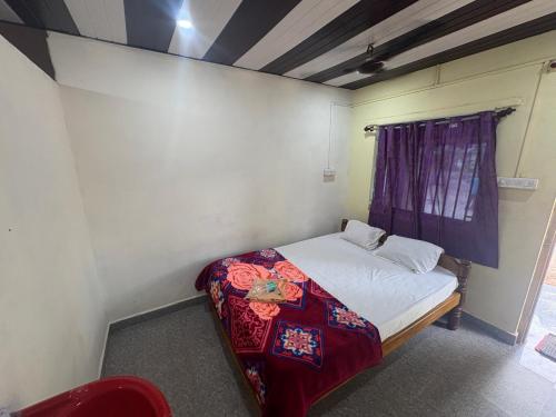 a small bedroom with a bed in a room at Coco beach front stay in Gokarn