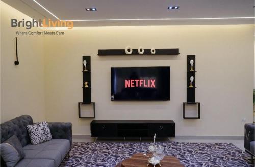 a living room with a couch and a tv on a wall at Modern Villa 1 min from Southpark Mall at Madinaty in Madinaty