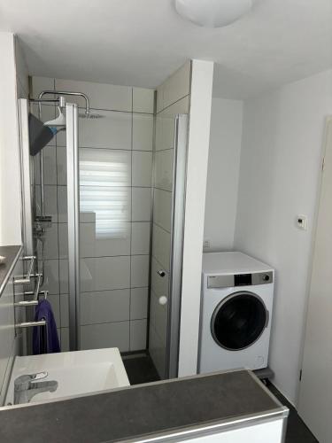 a bathroom with a washing machine and a sink at Trappe's Maar-Häuschen in Ulmen