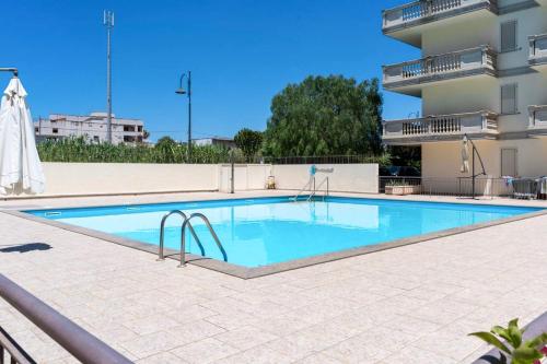 a large swimming pool in front of a building at Cariddi in Caulonia Marina