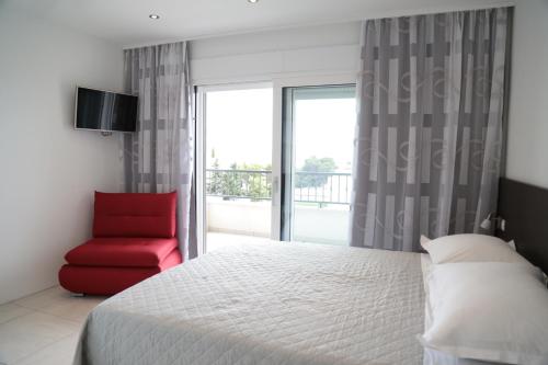 a bedroom with a bed and a red chair at Apartment Nada in Tučepi