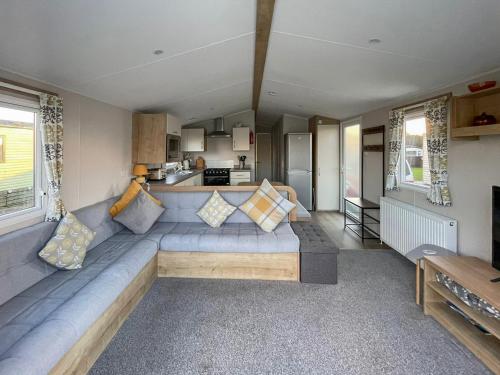 a living room with a long couch in a caravan at Edith Rose in Middleton