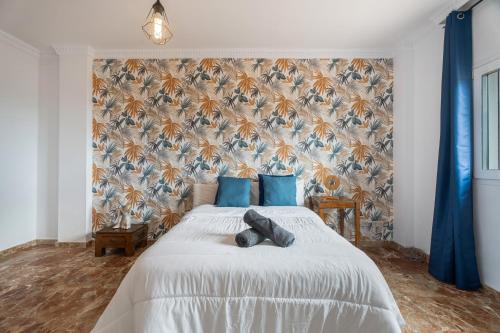 a bedroom with a large white bed with blue pillows at Villa Luxury el Mirador in Adeje