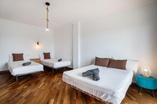two beds in a room with wooden floors at Villa Luxury el Mirador in Adeje