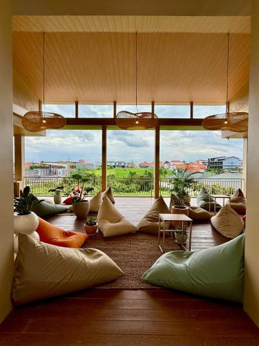 a room with pillows on the floor with a large window at KAIA Canggu in Canggu