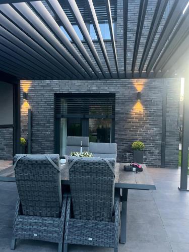 a patio with a table and chairs and a brick wall at Ferienhaus am Lankower See in Schwerin