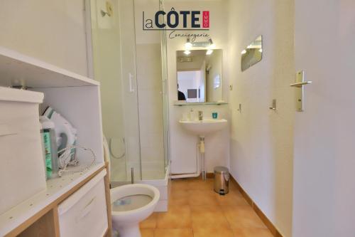een witte badkamer met een toilet en een wastafel bij Ciel et mer in Sausset-les-Pins