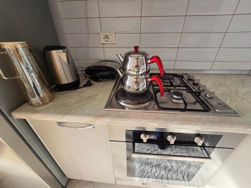a tea kettle sitting on top of a stove in a kitchen at Terminal apartment- near North and South Terminal in Bregu i Lumit