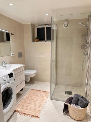 y baño con ducha y lavadora. en Free parking Apartment in Ålesund, en Ålesund