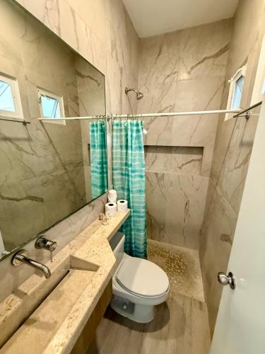 a bathroom with a toilet and a sink and a mirror at SelvaMar Estudios Playa in Playa del Carmen