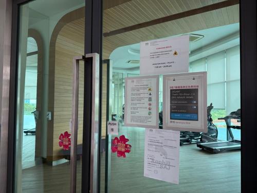 a glass door with signs on the wall of a building at The M Medini Macrolink by Cactus Homestay in Iskandar Puteri