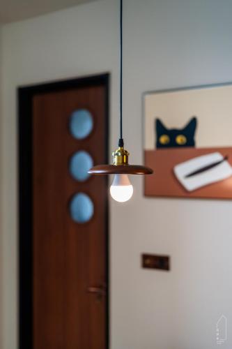 a pendant light hanging over a room with a door at The M Medini Macrolink by Cactus Homestay in Iskandar Puteri