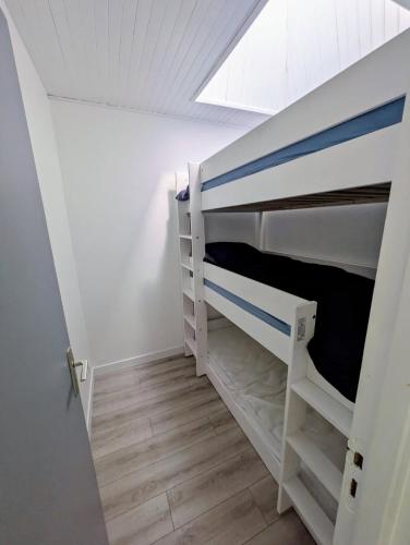 a bedroom with two bunk beds and a window at La Cahute des Tamaris in Mimizan-Plage