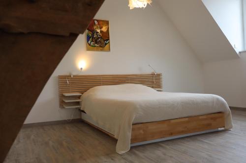 a bedroom with a bed in a white room at Le Minerai, maison de 6 couchages, avec jardin & parking, wifi - Larès in Mortrée