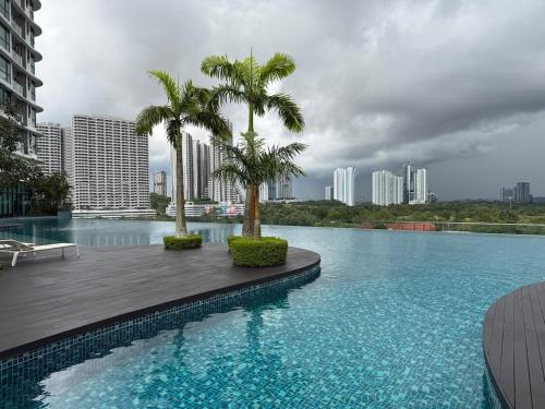 a swimming pool with two palm trees in a city at The M Medini Macrolink by Cactus Homestay in Iskandar Puteri