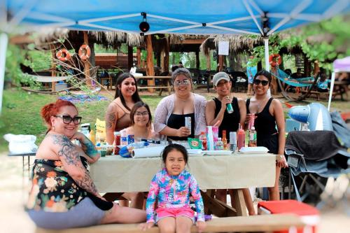 a group of people sitting around a table at a party at Dream Glamping Destination Suitable for Families: Comfortable Safari Tent on the San Marcos River near Kingsbury, Texas in Staples