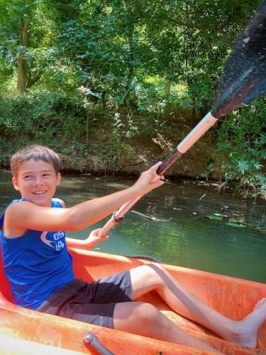 a young boy sitting in a boat holding a paddle at Rest and Relax in Texas in this Great Safari Tent Getaway in Cibolo in Marion