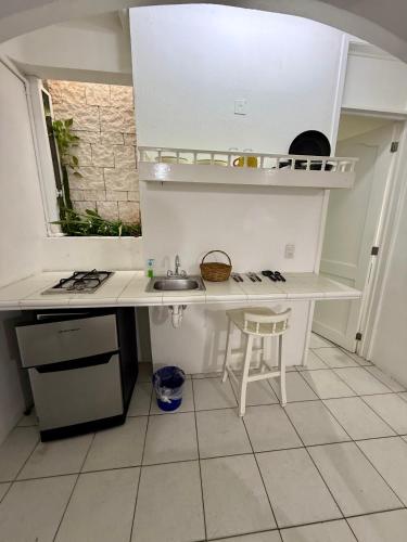 a white kitchen with a sink and a counter at SelvaMar Estudios Playa in Playa del Carmen