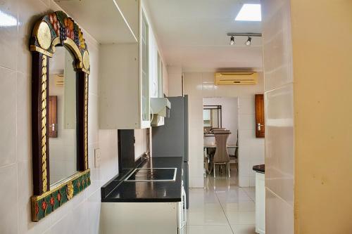 a kitchen with a sink and a mirror on the wall at Elroiairbnb in Amanzimtoti