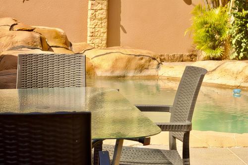 a table and two chairs and a swimming pool at Elroiairbnb in Amanzimtoti