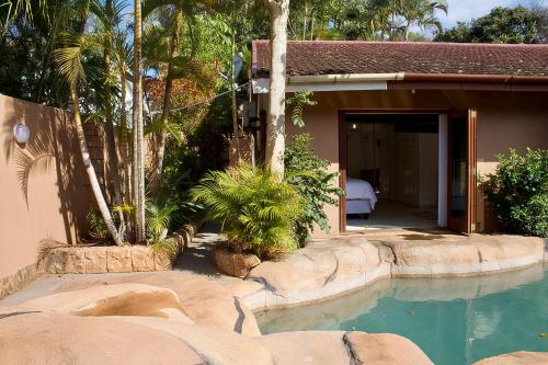 a swimming pool in front of a house at Elroiairbnb in Amanzimtoti