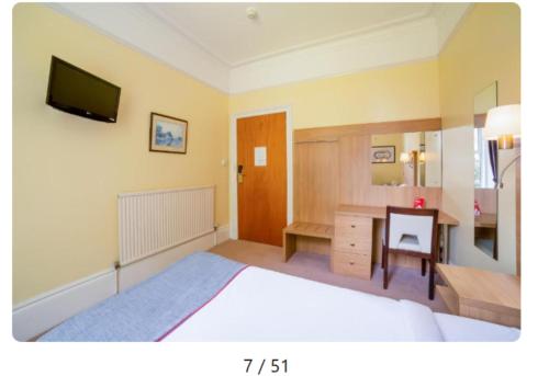 a bedroom with a bed and a desk and a television at OYO Eagle House Hotel, St Leonards Hastings in St. Leonards