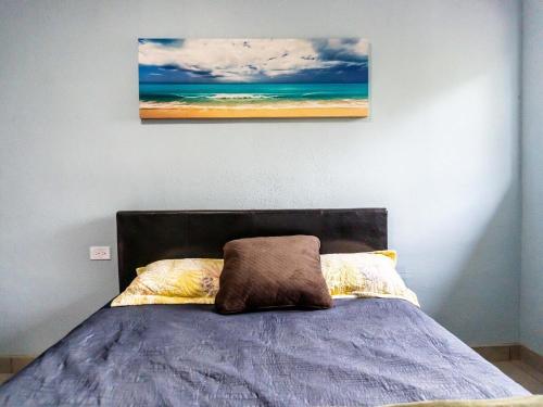 a bedroom with a bed with a painting on the wall at Rocky Point Casa Mango w Pool Walk to Beach in Ciudad Constitución