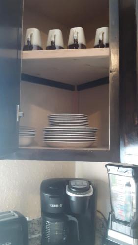 a cupboard with plates and cups and a coffee maker at Rocky Point Casa Mango w Pool Walk to Beach in Ciudad Constitución