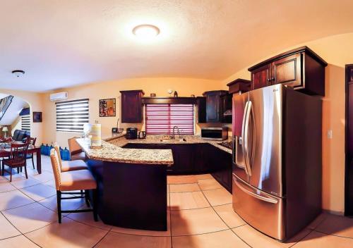 a kitchen with a stainless steel refrigerator and a table at Rocky Point Casa Mango w Pool Walk to Beach in Ciudad Constitución