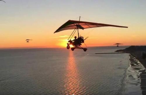 a biplane flying over the ocean with the sunset at Rocky Point Casa Mango w Pool Walk to Beach in Ciudad Constitución