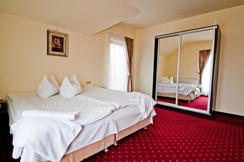 a hotel room with two beds and a mirror at Pensiunea Schwartz in Cluj-Napoca