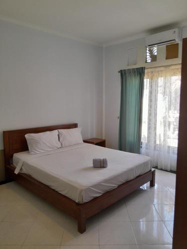 a bedroom with a bed and a window at Astina Garden Jln Temu Dewi1 Badung Bali in Uluwatu