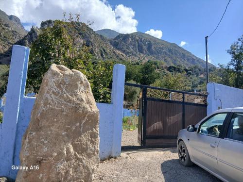a rock in front of a gate with a car at Blue House Town in Chefchaouene