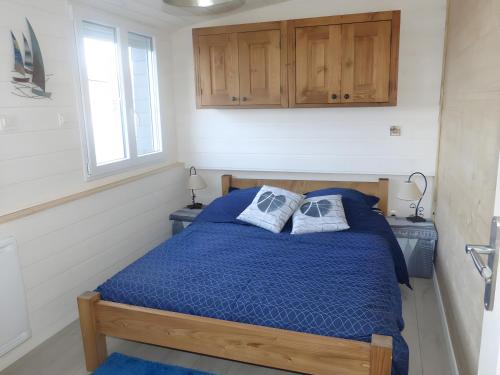 a bedroom with a blue bed with two pillows at Chez Isa Maison de pêcheur Etretat in Yport