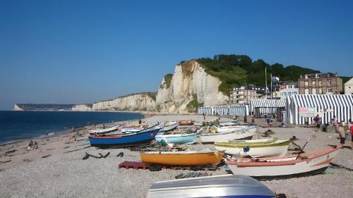 a group of boats sitting on a beach at Chez Isa Maison de pêcheur Etretat in Yport