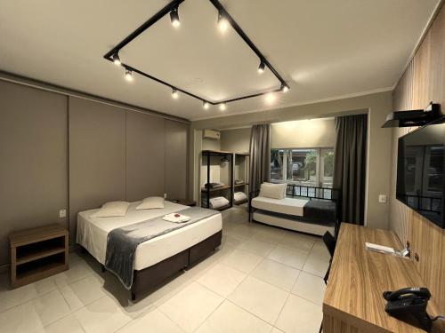 a bedroom with a bed and a desk in it at Hotel Locatelli in Lajeado