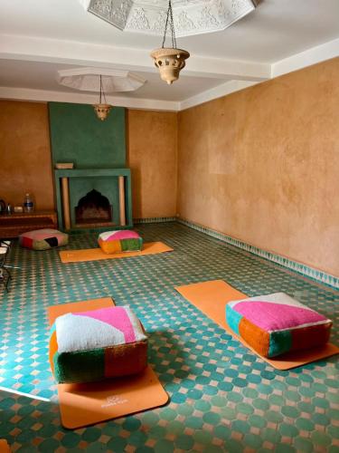a room with two beds on the floor with a fireplace at Riad TAWALA Surfing Mind in Tamraght Ouzdar