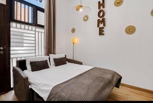 a bedroom with a bed with white sheets and pillows at URBAN LOFT VALENCIA in Valencia