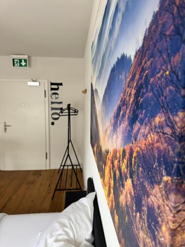 a bedroom with a large painting on the wall at Zentrales Apartment St Gallen in St. Gallen