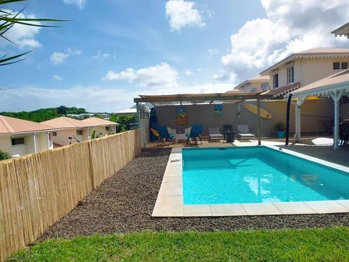 a swimming pool in front of a house at Villa Zandoli in Le Diamant
