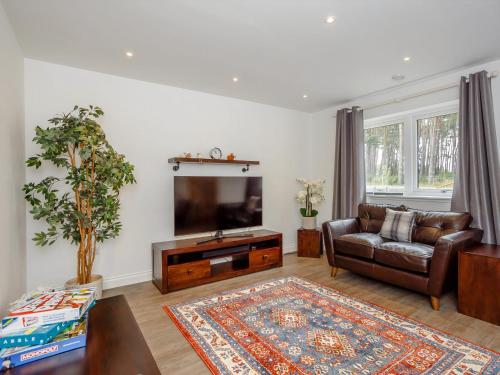 a living room with a couch and a flat screen tv at Strathclaggan in Aberlour