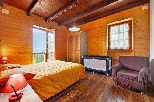 a bedroom with a bed and a chair at La Vieille École Montjovet in Fenillettaz