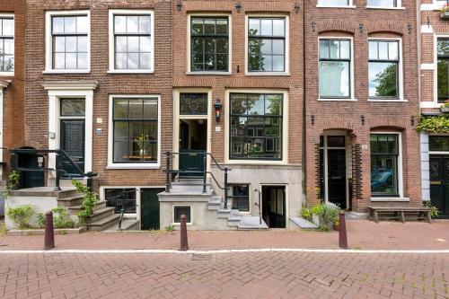 a brick building with a staircase in front of it at Charming souterrain studio at Bloemgracht 30 in Amsterdam