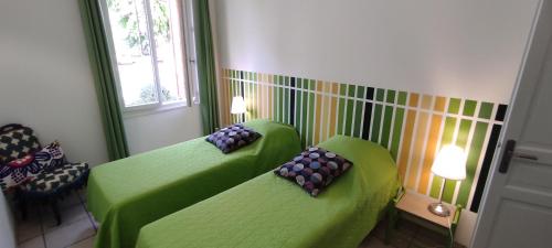Dos sofás verdes con almohadas en una habitación. en Gîte Lavande, en Entrechaux