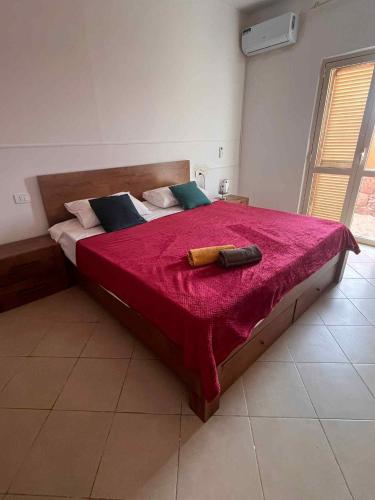 una camera da letto con un letto grande con una coperta rossa di Casa Minuxa a Santa Maria