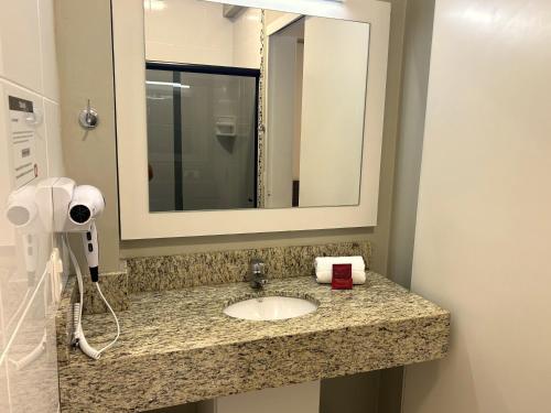 a bathroom with a sink and a mirror at Hotel Locatelli in Lajeado