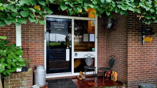 a front door of a brick building with a chair at Bed, Bikes and Breakfast, City Farmer Amsterdam a Guesthouse with Free Parking in Amsterdam