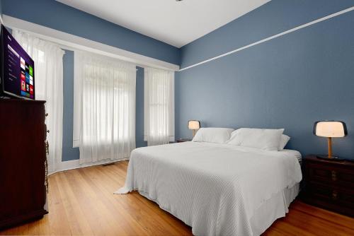 a bedroom with a large white bed and blue walls at Ellie Marie House LITE in Seguin