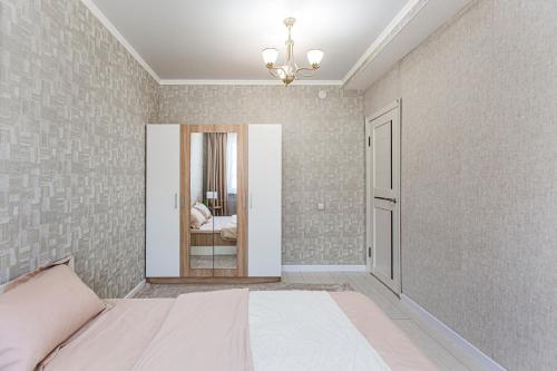 a bedroom with a bed and a mirror at BAYHOUSE - Апартаменты в ЖК Уш Сункар in Almaty